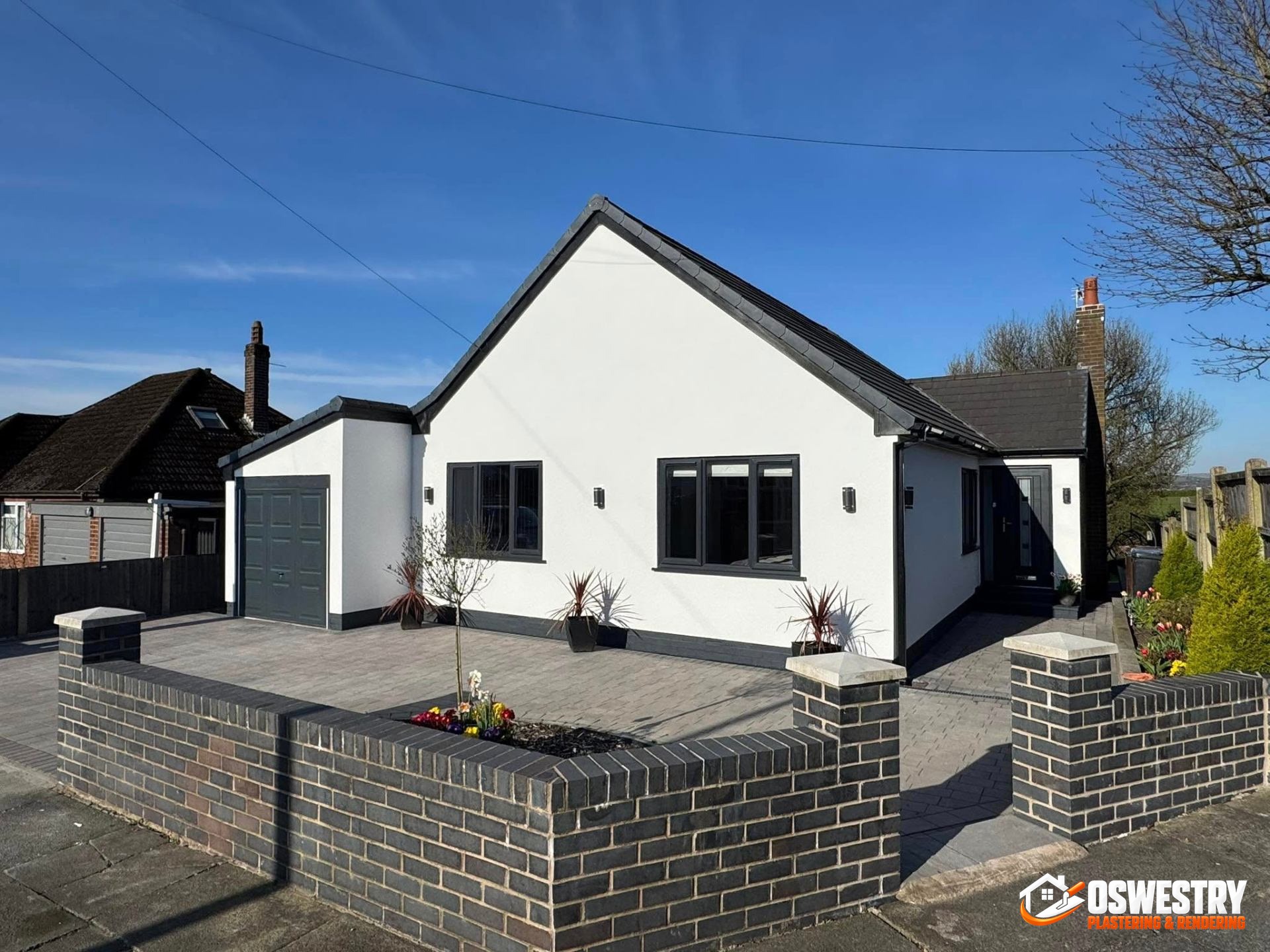 Semi-detached UK home finished in smooth white silicone render by Oswestry Plastering & Rendering across the front elevation